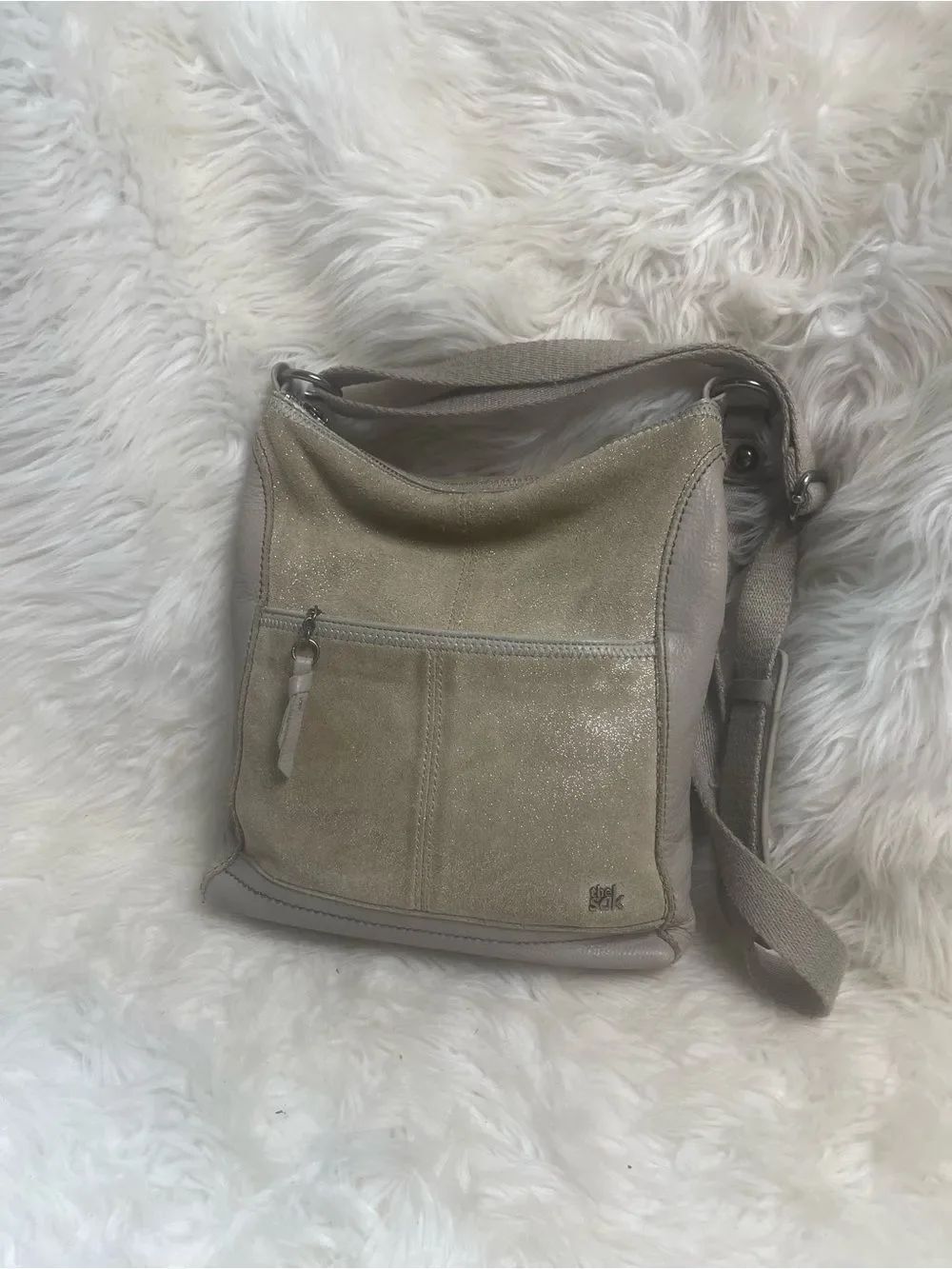 The SAK crossbody bag with a shimmering tan suede material &leather gray side.